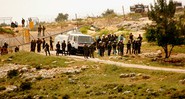 Soldados israelenses posicionados próximos à cerca em Bil'in, aguardando os manifestantes