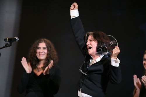 Anna Muylaert (ao fundo) e a produtora Sara Silveira recebem o prêmio de melhor longa-metragem de ficção - Divulgação/ Márcio Nunes