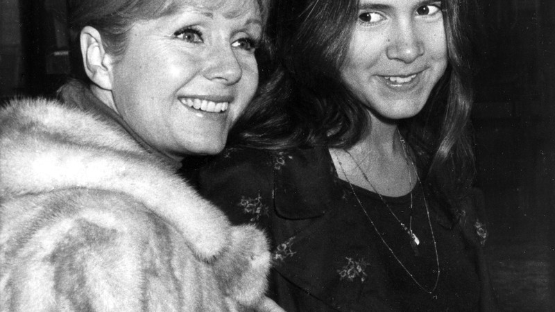 Carrie Fisher, aos 15 anos, com a mãe Debbie Reynolds, a caminho do aeroporto Heathrow em Londres, Inglaterra, no dia 12 de fevereiro de 1972. - AP