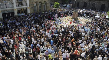 Multidão se reúne na praça St. Ann, em Manchester, para um minuto de silêncio em homenagem às vítimas do atentado terrorista que ocorreu na Manchester Arena, no dia 22 de maio, após show da cantora Ariana Grande


 - AP