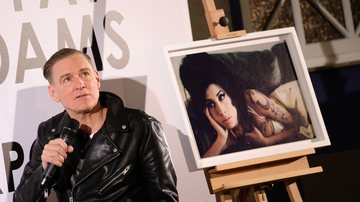 Bryan Adams ao lado de foto de Amy Winehouse (Foto: Andreas Rentz/Getty Images)