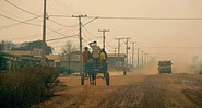 Distrito de Colniza com uma única rua; durante a seca, a poeira se choca com a fumaça no céu vinda das queimadas