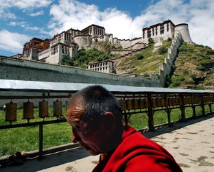 Monge caminha em Lhasa, em frente ao Palácio Potala - que já foi sede do governo tibetano