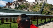 Monge caminha em Lhasa, em frente ao Palácio Potala - que já foi sede do governo tibetano - Eugene Hoshiko/AP