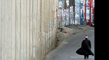 Em 2006, um cidadão palestino caminha ao lado do que Israel chama de "Cerca de Segurança", na cidade de Abu Dis - Pedro Carrilho