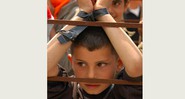 Menino "enjaulado" e com as mãos amarradas protesta no Dia do Prisioneiro, Bil'in