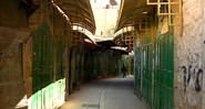 Rua deserta e lojas fechadas no centro histórico de Hebron, ocupado parcialmente por colonos radicais