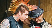 Lars Frederiksen, do Rancid, exibe seu moicano tingido ao lado do vocalista Tim Armstrong (que antes de preferir o chapéu, também usou moicano)