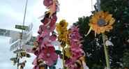 Flores falsas enfeitam cruzamento de caminhos do sítio que recebe o festival