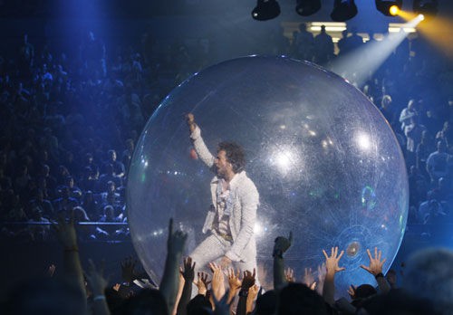 Wayne Coyne passeia pela plateia em sua indefectível esfera de plástico, que deve aparecer no clipe de "Watching The Planets" - AP