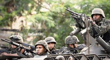 FORÇA BRUTA Soldados do Exército se posicionam diante do Morro do Alemão (RJ), em 27 de novembro: apesar da ofensiva, problema com o narcotráfico não deverá dimunuir - EVARISTO SA/AFP/GETTY IMAGES