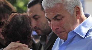 Mitch Winehouse lamenta a morte da filha, enquanto Janis (ao fundo) é consolada - AP