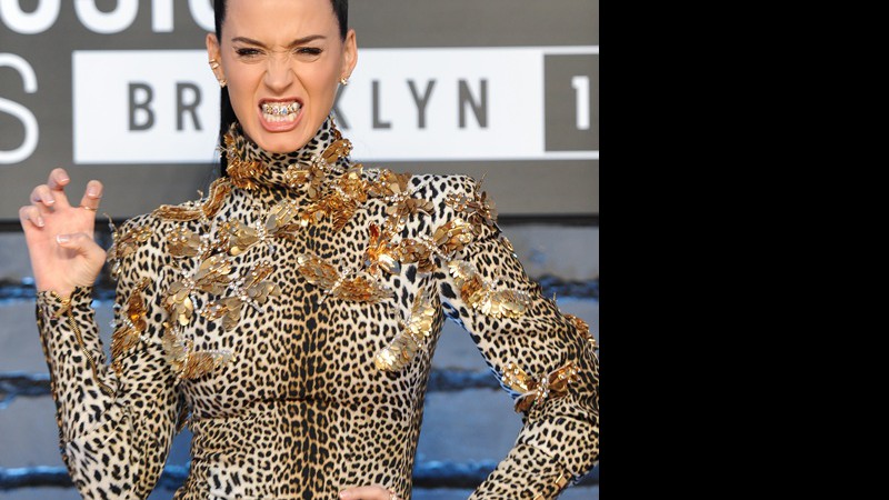 Katy Perry vestindo Emanuel Ungaro, de estampa felina combinando com o tema da música "Roar", e com uma daquelas "grelhas" douradas nos dentes