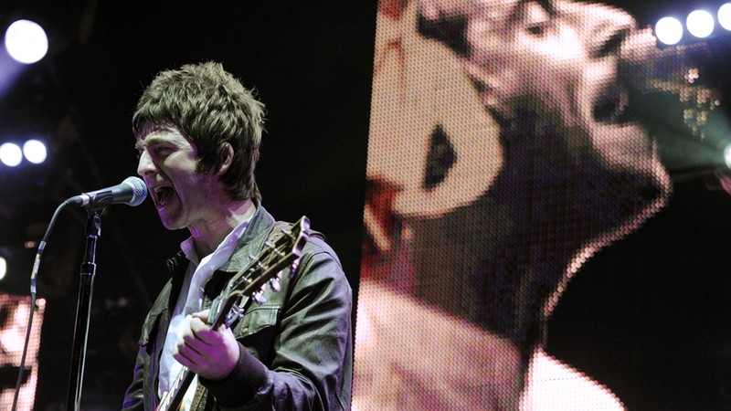 Noel Gallagher com Liam ao fundo, em um show do Oasis em 2008