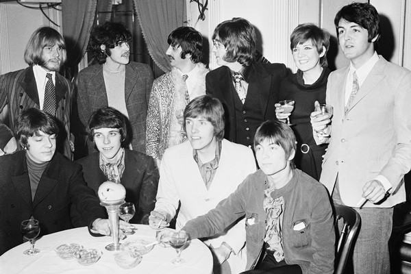 Cantora Cilla Black - acima, à direita, ao lado de Paul McCartney - em foto com os Beatles e com Brian Jones