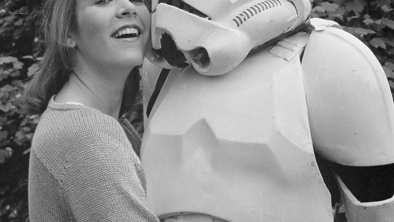 Carrie Fisher posando ao lado de um Stormtrooper em Londres, Inglaterra, no dia 23 de maio de 1980. A atriz estava na cidade divulgando o filme Star Wars: Episódio V - O Império Contra-Ataca.