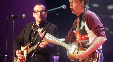 Elvis Costello e Paul McCartney durante o show <i>Here There and Everywhere A Concert for Linda</i>, que aconteceu em 1999, no Royal Albert Hall, em Londres - Sean Dempsey/AP