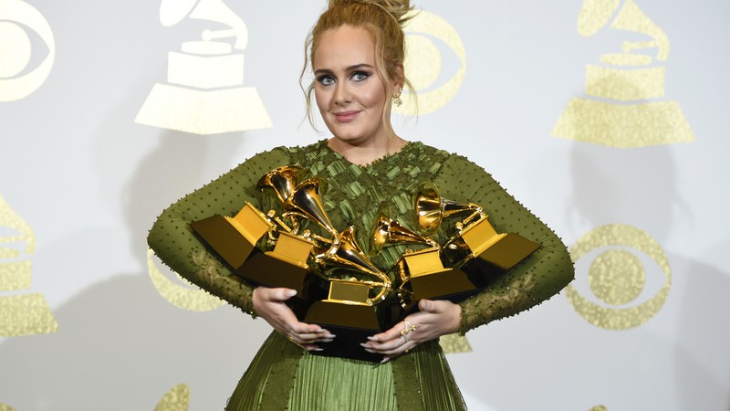 Adele exibindo os gramofones de ouro ganhados no Grammy 2017