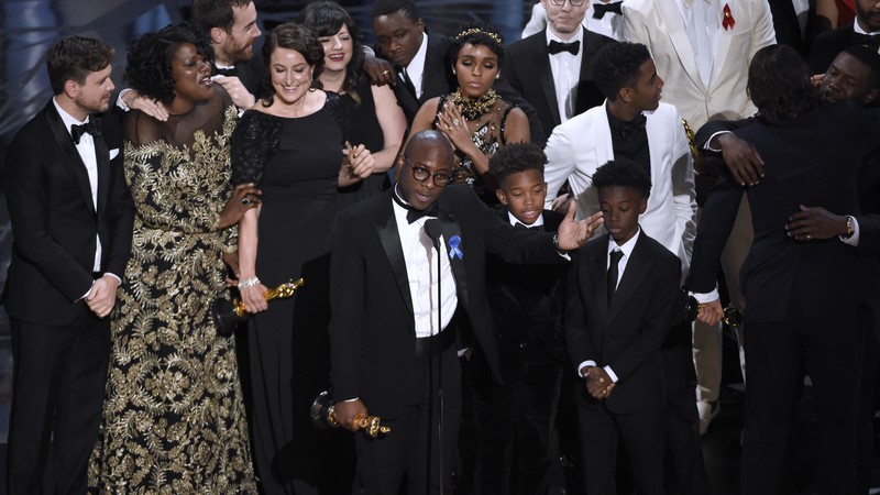 Barry Jenkins (no centro), cercado pelo elenco e equipe de Moonlight: Sob a Luz do Luar, aceitando o Oscar de Melhor Filme