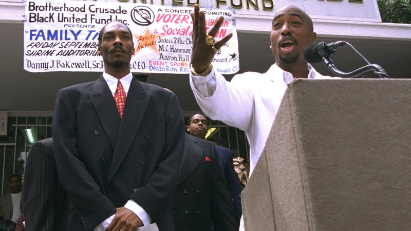 Tupac Shakur e Snoop Dogg durante conferência em Los Angeles, nos Estados Unidos, em 1996