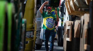 Apoiador anda entre caminhões durante ato em apoio a Bolsonaro em maio de 2021 (Foto: Andressa Anholete/Getty Images)