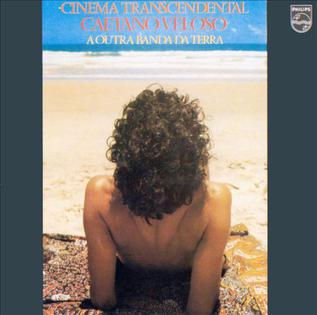 Cartano Veloso sentado de costas em uma praia. Capa do disco Cinema Transcendental.